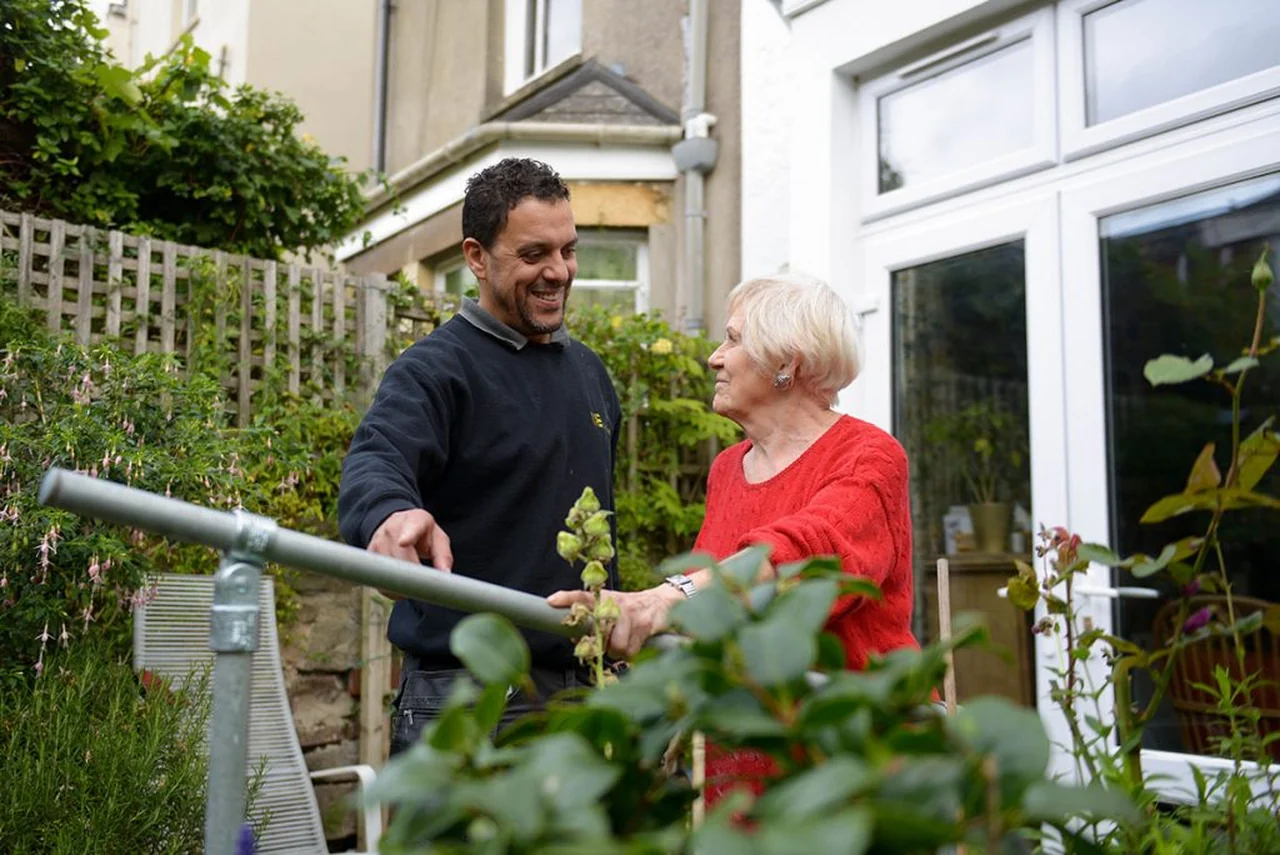 A home improvement worker speaking with a woman outside her home