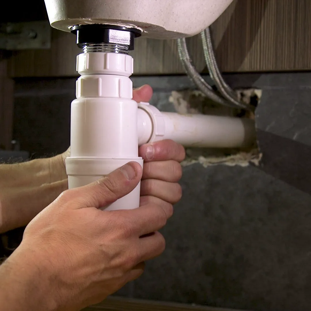 unscrewing a sink waste trap to unblock a sink